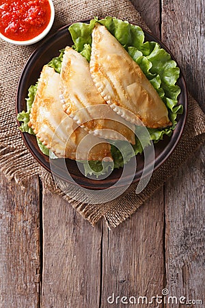 Empanadas and sauce closeup. vertical top view, rustic Stock Photo
