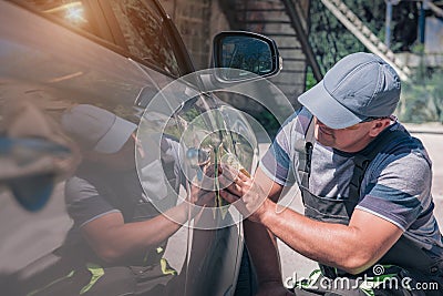 An employee of a car service examines a car paintwork Stock Photo