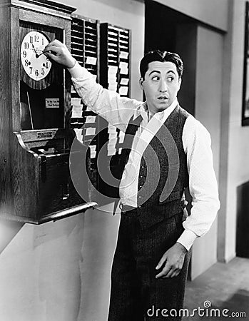 Employee changing time clock Stock Photo