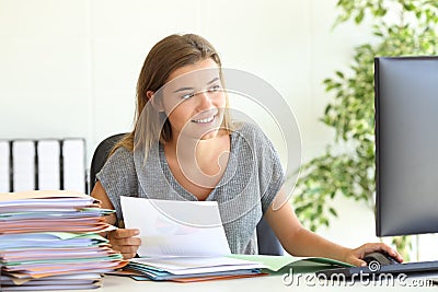 Employee comparing report online at office Stock Photo
