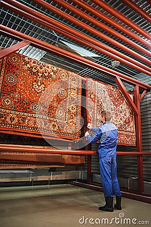 The employee corrects the Laundry hanging in the drying room, the rugs Stock Photo