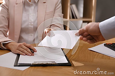 Employee giving resignation letter to boss in office Stock Photo