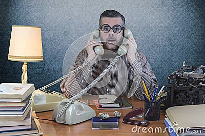 Employee with glasses talking on the phone in the office Stock Photo