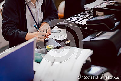 Employee hand writing bank cheque at counter. Stock Photo