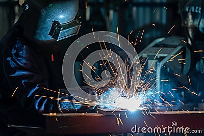 An employee or heavy industrial worker inside factory with industrial worker using welding machine. Industrial safety first Stock Photo