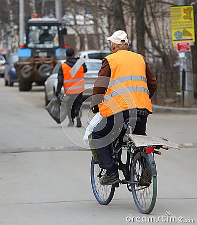 The employee of the municipal service for cleaning the streets on a Bicycle Editorial Stock Photo