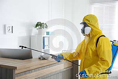 Employee in protective suit sanitizing office. Medical disinfection Stock Photo