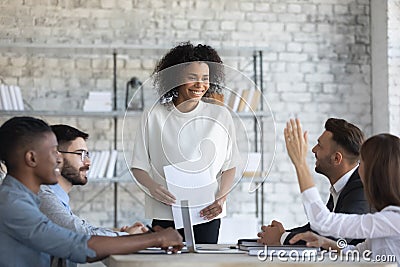 Employee raising hand, asking question to African American business coach Stock Photo