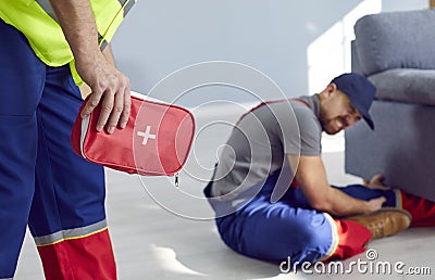 Employee of relocation service is going to provide medical care to injured colleague. Stock Photo