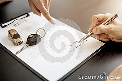 An employee of the rental car company points to the contract. Stock Photo