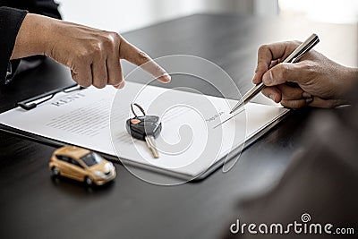An employee of the rental car company points to the contract. Stock Photo