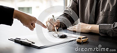 An employee of the rental car company points to the contract. Stock Photo