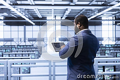 Admin in high tech data center making sure rackmounts are functioning Stock Photo