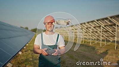 An employee of a solar power plant talks on a walkie-talkie while his colleagues and an investor check the solar power Stock Photo