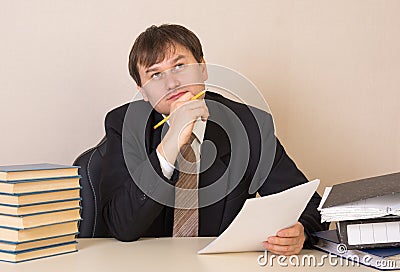 The employee thought about the document at table in the office Stock Photo