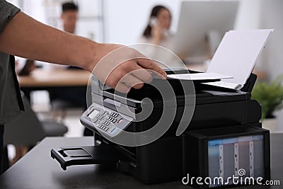 Employee using modern printer in office, closeup Stock Photo