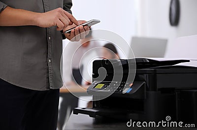 Employee using modern printer in office, closeup Stock Photo