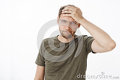 Employees like pain in ass. Portrait of irritated and annoyed young bothered businessman in glasses and dark-green t Stock Photo