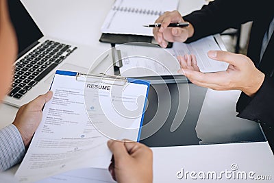 Employer or recruiter holding reading a resume during about colloquy his profile of candidate, employer in suit is conducting a Stock Photo