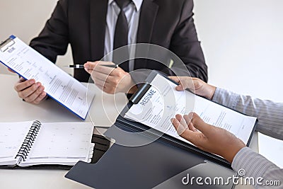 Employer or recruiter holding reading a resume during about colloquy his profile of candidate, employer in suit is conducting a Stock Photo