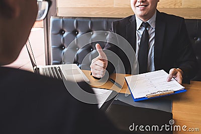 Employer or recruiter holding reading a resume during about his Stock Photo