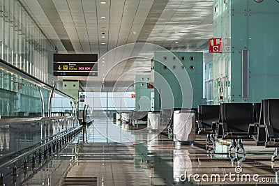 Empty airport lounge area with seats, moving walkway, trash cans and scoreboard. Stock Photo