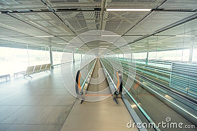 Empty airport terminal due to coronavirus pandemic and suspended airline flights. Empty airport terminal. Mechanical corridor with Stock Photo