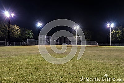 Empty baseball field at night with the lights on Stock Photo