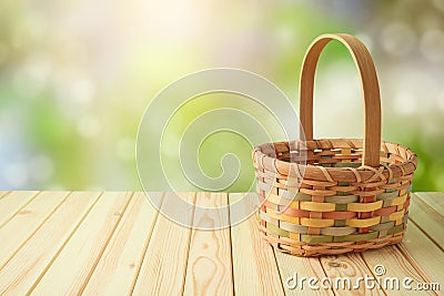 Empty basket on wooden table over green bokeh background. Spring and easter mock up for design Stock Photo