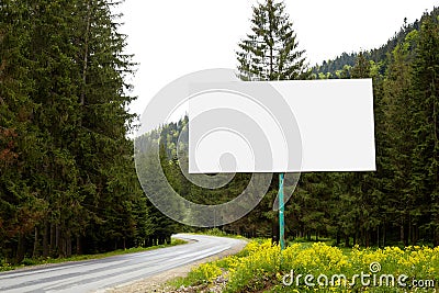 Empty billboard or big board on side of road with green forest and hills on background. Advertising blank, mock up, copy space for Stock Photo