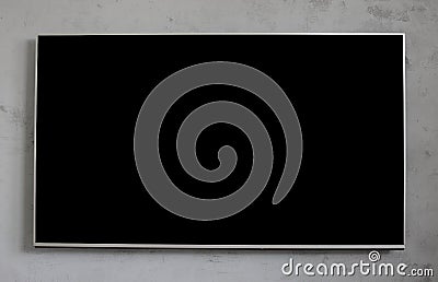 Empty black television screen on concrete wall. Stock Photo