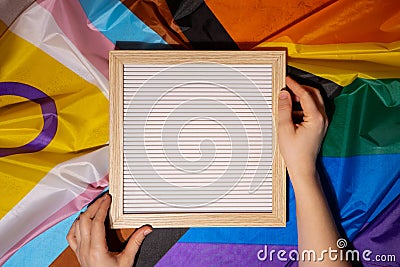 Empty blank frame on Rainbow LGBTQIA flag made from silk material with copy space for your text. Mock up template Stock Photo