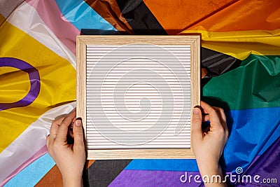 Empty blank frame on Rainbow LGBTQIA flag made from silk material with copy space for your text. Mock up template Stock Photo