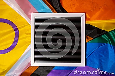 Empty blank frame on Rainbow LGBTQIA flag made from silk material with copy space for your text. Mock up template Stock Photo