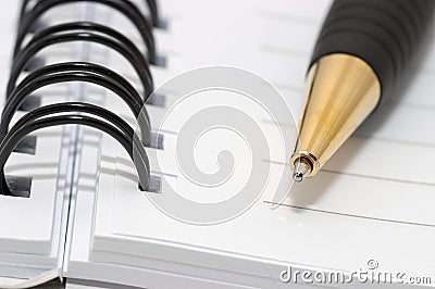 Empty blank ring, spiral notepad, gold pen closeup Stock Photo