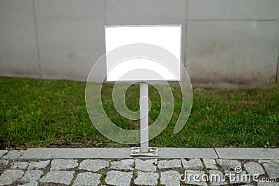 Empty blank sign board on a pole in a forest, template, advertising mock-up, banner on grass near Stock Photo