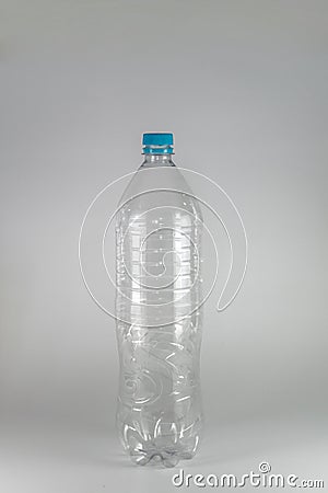 A empty bottle of a liter and a half of mineral water with blue cap and sealing ring on a white background, and space Stock Photo