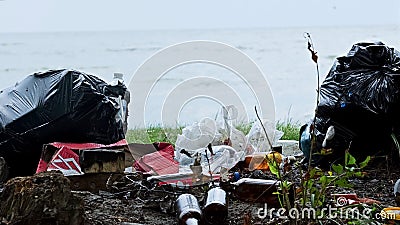 Empty bottles and containers polluting seashore, tons of garbage damaging nature Stock Photo