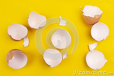Empty broken brown egg shells on yellow background Stock Photo