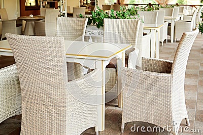 Empty cafe with rattan wicker armchairs and tables on summer garden. Stock Photo