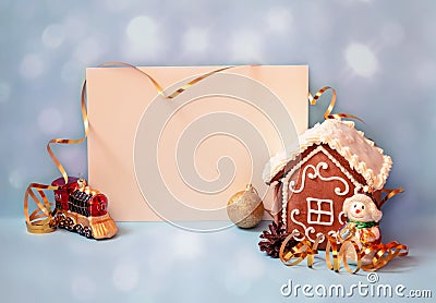 Empty card for your text, little gingerbread house and christmas decorations locomotive, snowman and ball on blue background Stock Photo