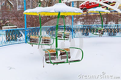 Empty carousels for children covered with snow in winter. Background with selective focus and copy space Stock Photo