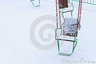 Empty carousels for children covered with snow in winter. Background with selective focus and copy space Stock Photo