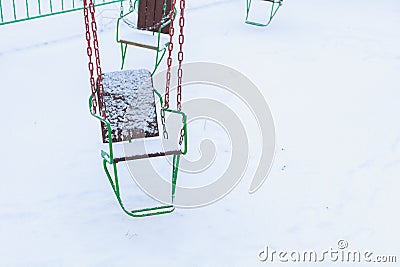 Empty carousels for children covered with snow in winter. Background with selective focus and copy space Stock Photo