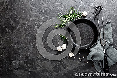 Empty cast iron frying pan on dark grey culinary background, view from above Stock Photo