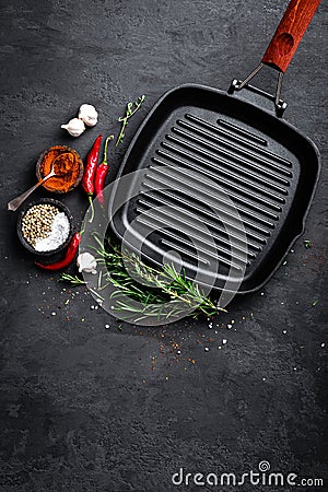 Empty cast-iron grill pan with ingredients for cooking on black background Stock Photo