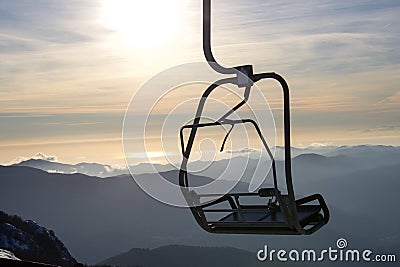 Empty chair lift silhouette in front of a beautiful panorama Stock Photo