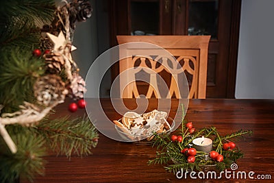 Empty chair at a table with burning candle, christmas decoration and gingerbread cookies, lonely holidays during coronavirus and Stock Photo