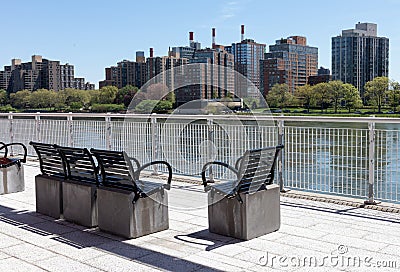 Empty Chairs at a Park on the Upper East Side with a view of the Roosevelt Island Skyline along the East River in New York City Editorial Stock Photo