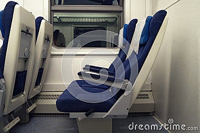 Empty chairs in the train side view. The interior of the railway wagon, carriage with blue seats Stock Photo